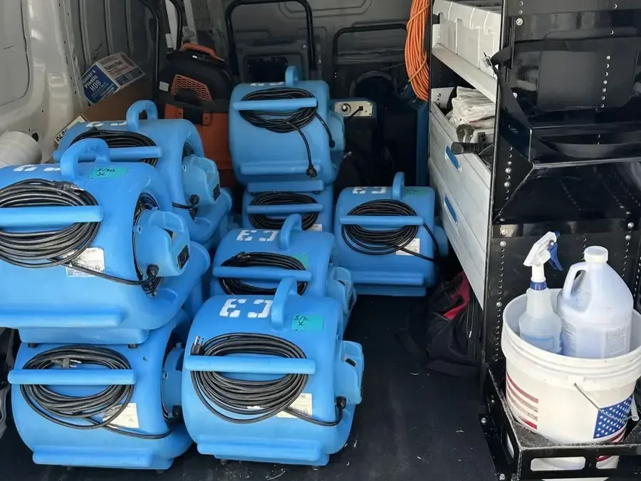 Air movers, a dehumidifier and cleaning supplies packed in a restoration van
