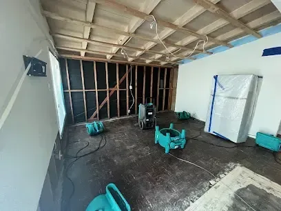 Opened walls and ceiling with air movers drying the exposed framing