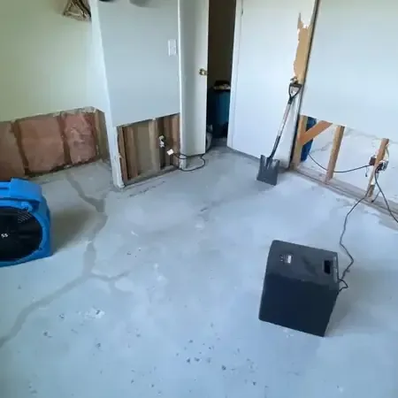 Air movers and a dehumidifier working together in a room with open wall cavities